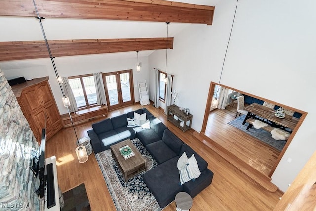 living room featuring beam ceiling, french doors, high vaulted ceiling, and wood finished floors