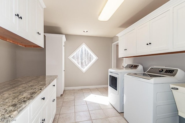 laundry area featuring light tile patterned floors, baseboards, cabinet space, separate washer and dryer, and a sink