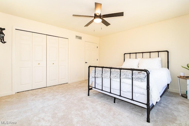 carpeted bedroom with a ceiling fan, baseboards, visible vents, and a closet