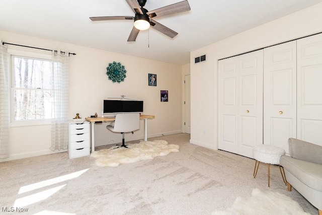 office with visible vents, carpet flooring, baseboards, and a ceiling fan