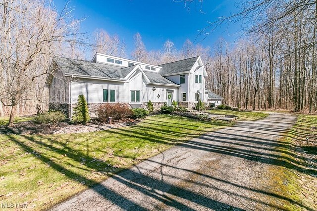 view of property exterior with a lawn and driveway