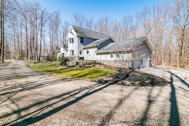 view of home's exterior with a yard, driveway, and a garage