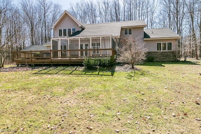 back of house with a deck, a lawn, and a shingled roof