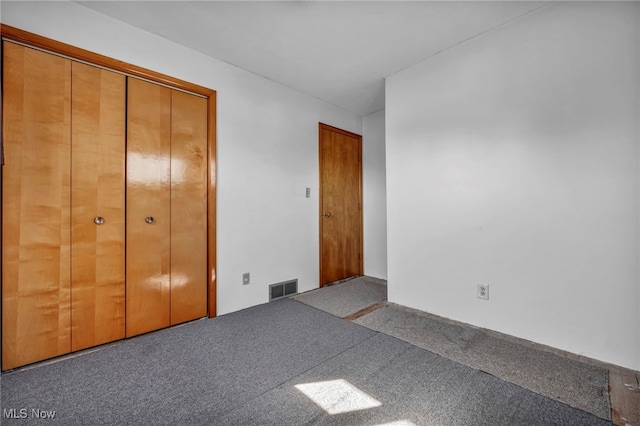 unfurnished bedroom with visible vents and carpet