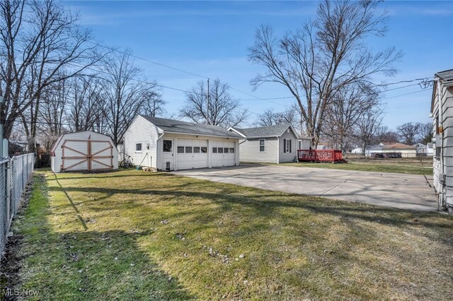 exterior space featuring an outbuilding, a detached garage, and fence