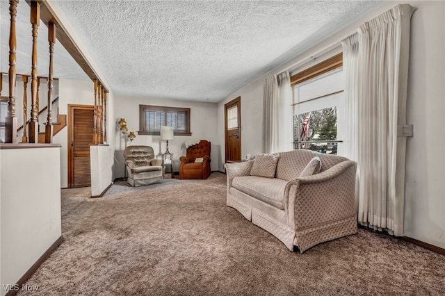 carpeted living room with baseboards and a textured ceiling