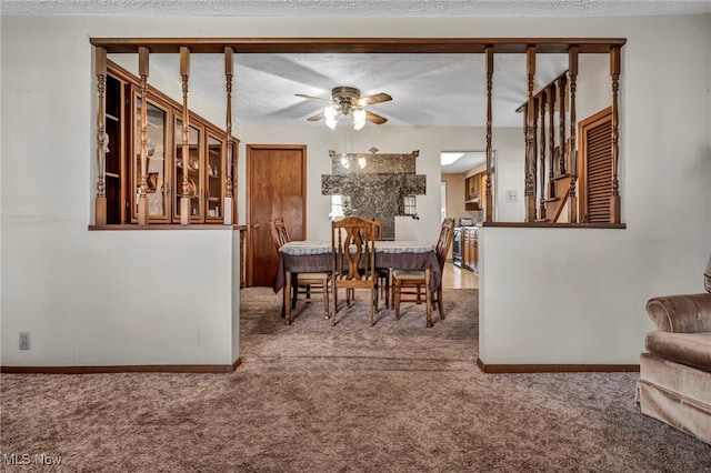 carpeted dining space with baseboards, a textured ceiling, and a ceiling fan