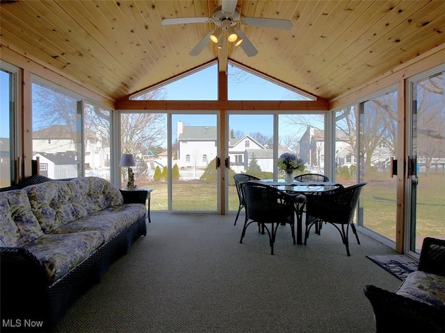 sunroom / solarium featuring a healthy amount of sunlight, ceiling fan, wooden ceiling, and vaulted ceiling