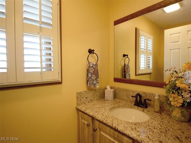 bathroom with a textured ceiling and vanity