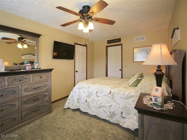 carpeted bedroom with visible vents, baseboards, a textured ceiling, and ceiling fan