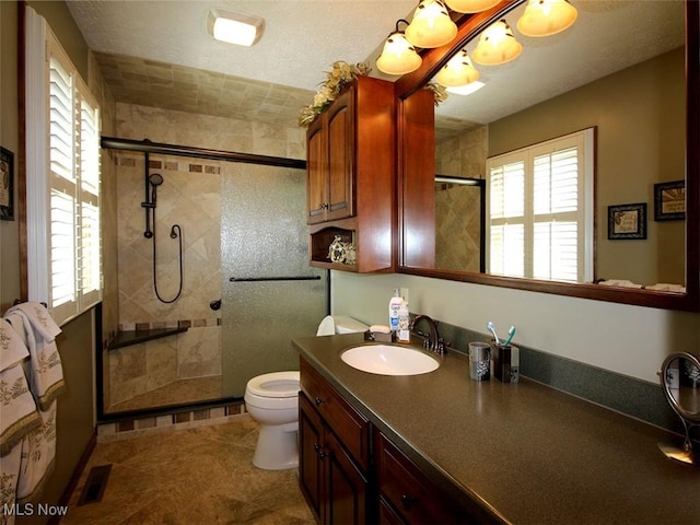 full bathroom with vanity, a textured ceiling, toilet, and tiled shower