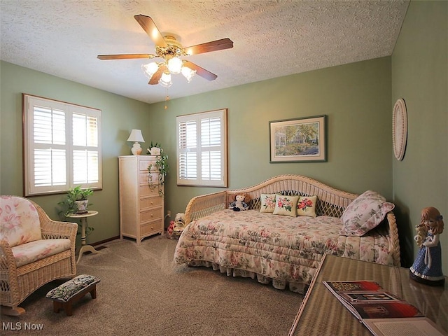 carpeted bedroom featuring multiple windows, a textured ceiling, and ceiling fan