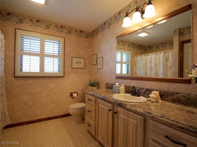 bathroom featuring curtained shower, wallpapered walls, baseboards, toilet, and vanity