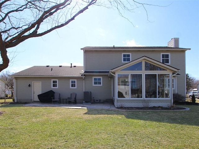 back of house featuring a patio area, central air condition unit, a lawn, and a chimney