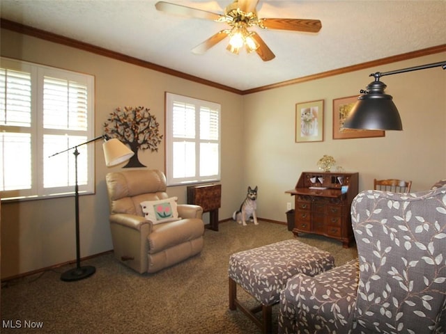 sitting room with a ceiling fan, baseboards, carpet, and crown molding