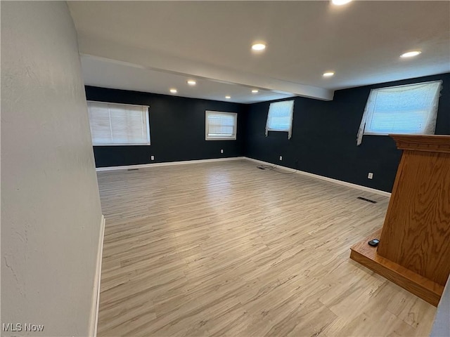 spare room featuring beamed ceiling, recessed lighting, baseboards, and light wood-type flooring