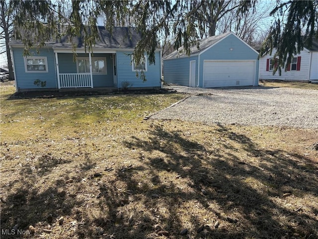 exterior space with a porch, a garage, an outdoor structure, and a front lawn