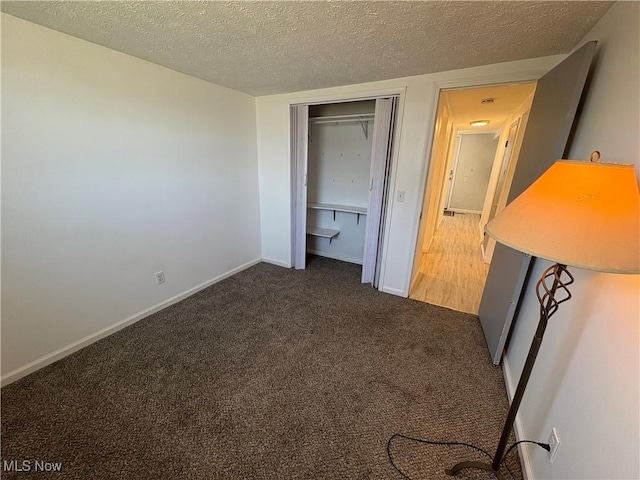 unfurnished bedroom featuring a closet, baseboards, carpet, and a textured ceiling