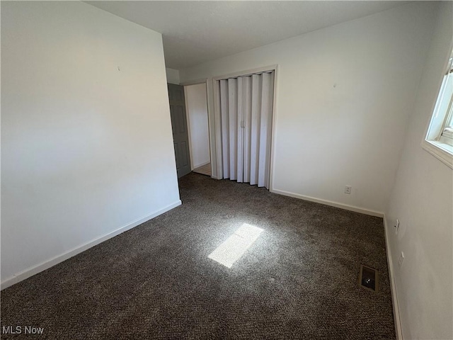 unfurnished room with baseboards and carpet floors