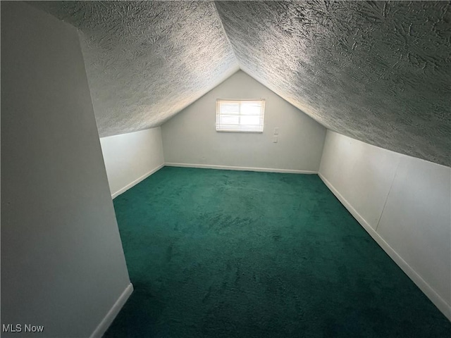 additional living space with baseboards, carpet floors, a textured ceiling, and lofted ceiling