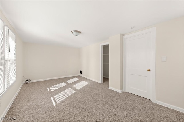 spare room with baseboards and carpet floors