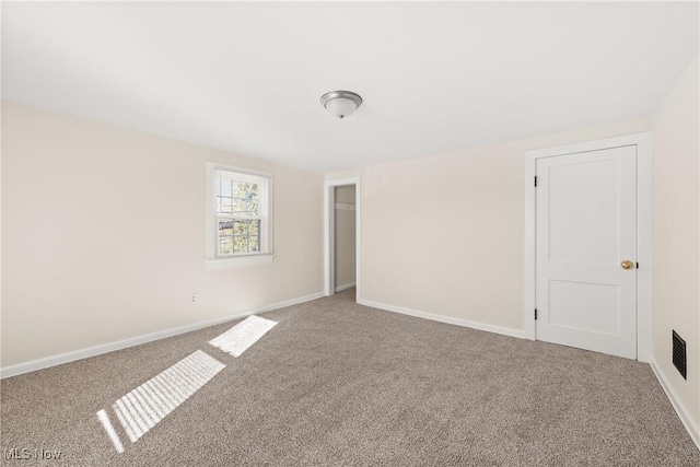 spare room featuring visible vents, baseboards, and carpet flooring