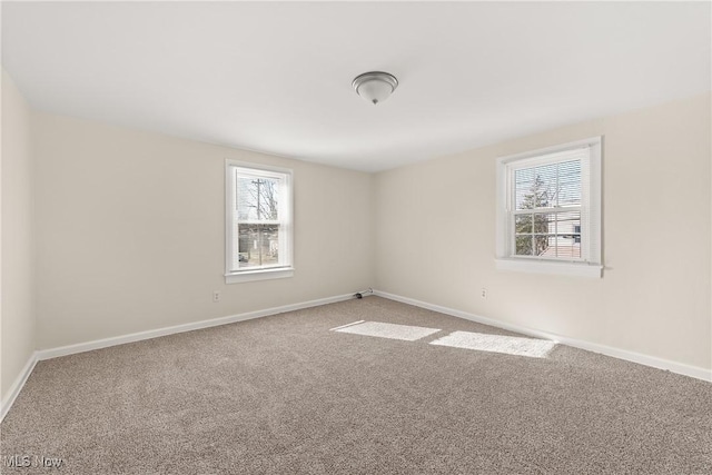 carpeted spare room with baseboards