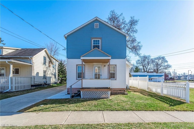 view of front of home with driveway, a front yard, and fence