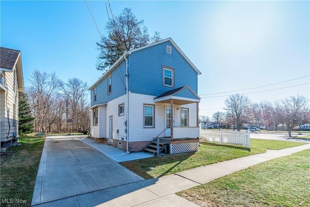 view of front of house with a front yard, covered porch, and driveway