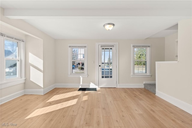 entrance foyer with a wealth of natural light, light wood-type flooring, and baseboards