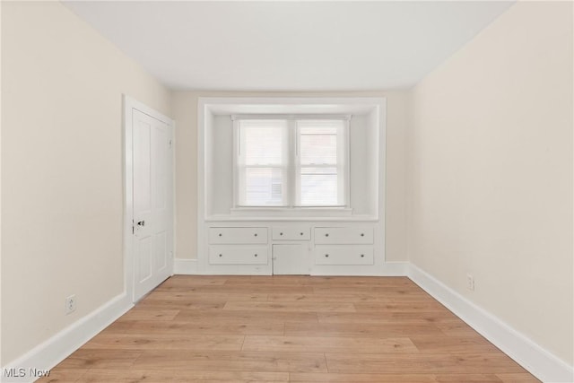 empty room with light wood-style flooring and baseboards