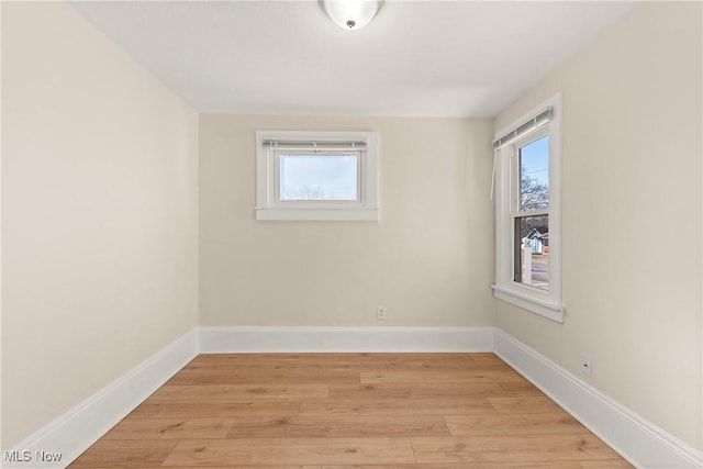 unfurnished room with light wood-type flooring, plenty of natural light, and baseboards