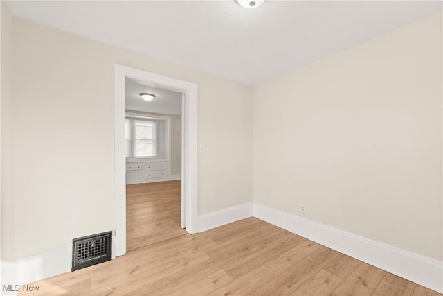 spare room with visible vents, light wood-style flooring, and baseboards