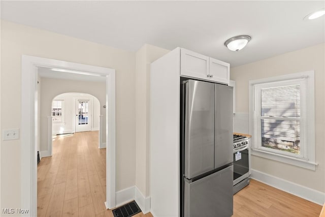 kitchen featuring visible vents, stainless steel appliances, a healthy amount of sunlight, and white cabinetry