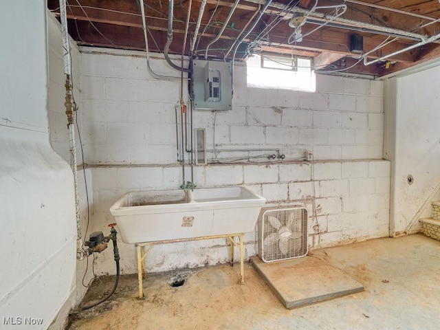 basement featuring electric panel and a sink