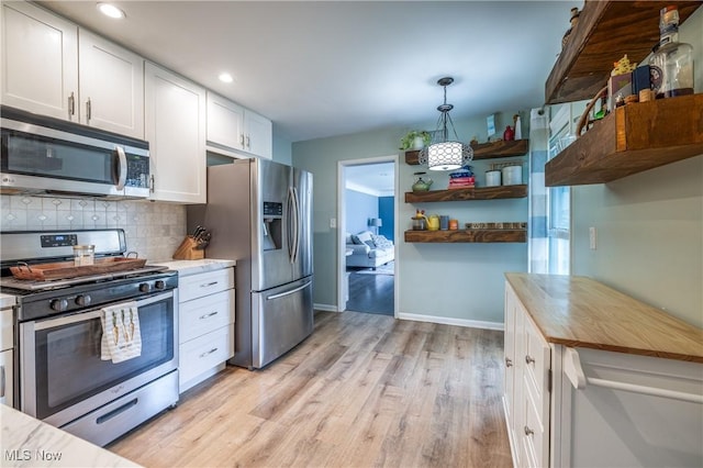 kitchen featuring decorative backsplash, appliances with stainless steel finishes, light wood-style floors, white cabinetry, and open shelves