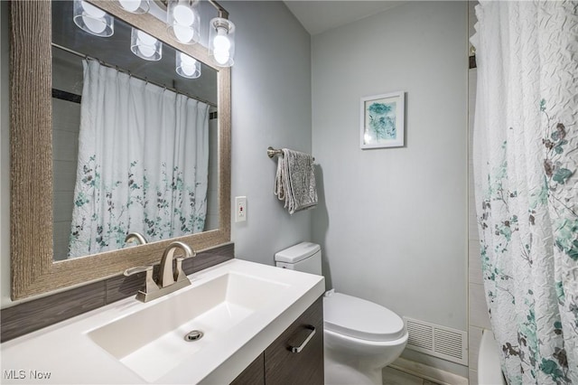 bathroom featuring visible vents, toilet, and vanity