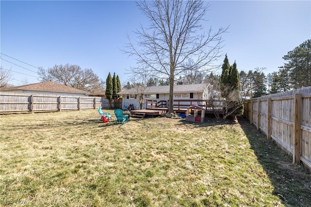 view of yard with a wooden deck and a fenced backyard