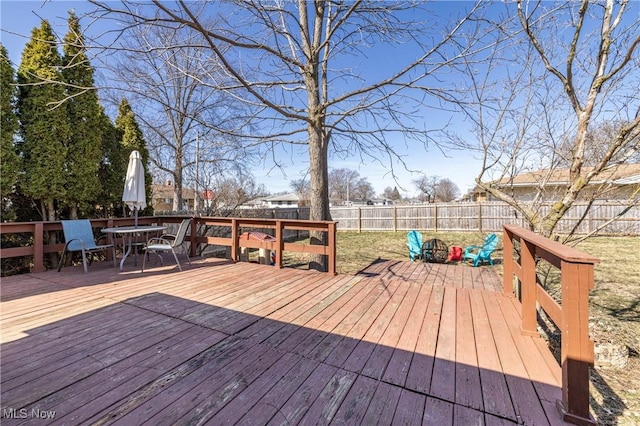 deck featuring outdoor dining area and a fenced backyard