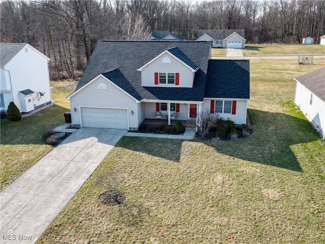 traditional-style home with covered porch, an attached garage, concrete driveway, and a front lawn