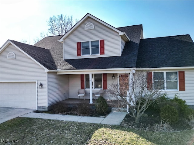 traditional home featuring a garage, covered porch, driveway, and a shingled roof