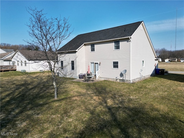 back of house with a yard, a patio area, and a shingled roof