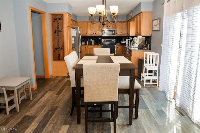 dining room with dark wood finished floors and a notable chandelier