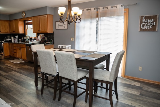 dining space featuring dark wood-type flooring, a notable chandelier, and baseboards