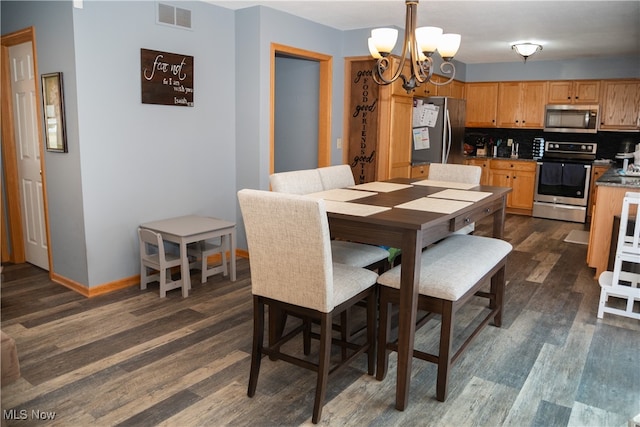 dining space featuring an inviting chandelier, dark wood-style floors, visible vents, and baseboards