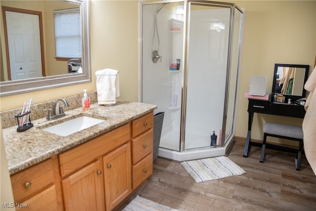 full bath featuring vanity, wood finished floors, and a shower stall