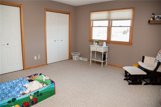 interior space featuring baseboards and two closets