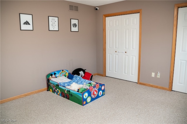 bedroom with visible vents, baseboards, carpet, and a closet