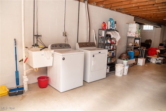 laundry area featuring laundry area, washer and dryer, concrete block wall, and a sink