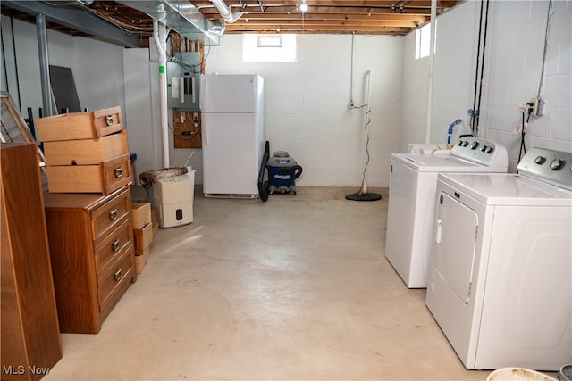 basement featuring electric panel, washer and clothes dryer, and freestanding refrigerator